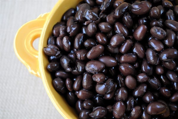 Cooked black beans in a bowl. A 1/2 cup serving gives you 7.5 grams of fiber and the same amount of protein.
