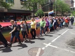 Spokane Pride Parade marchers carry a rainbow flag through downtown.
