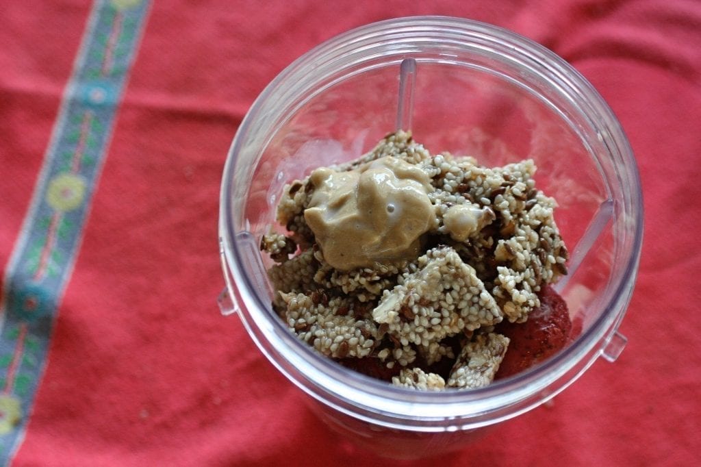 A Mixed Nut Medley BumbleBar and cashew butter for creaminess sit at the top of the blender cup, ready to be blended.