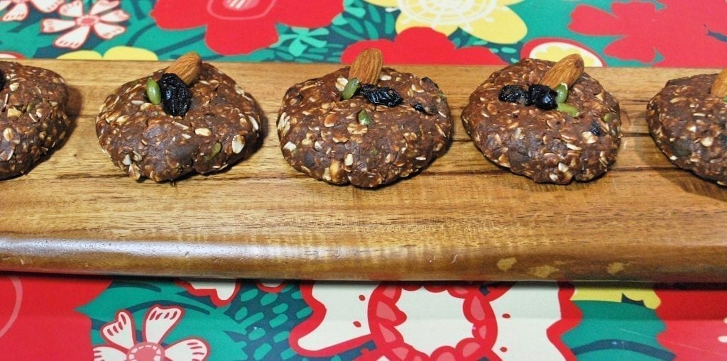 No-bake healthy holiday maca cookies lined up on a cutting board.