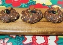 No-bake healthy holiday maca cookies lined up on a cutting board.