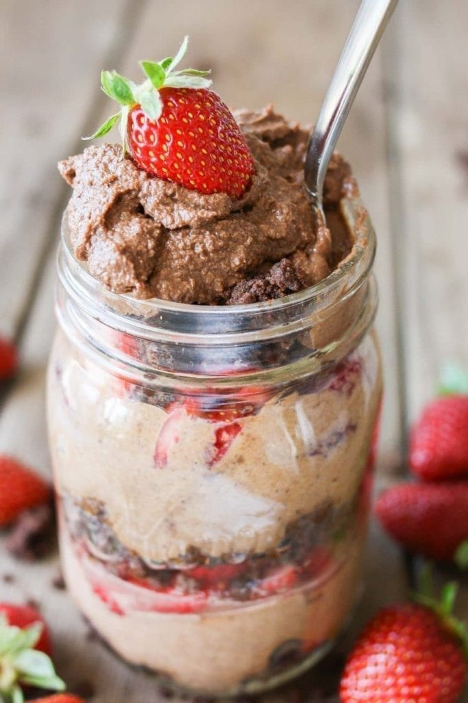 Vegan chocolate mousse in a mason jar, topped with a strawberry 