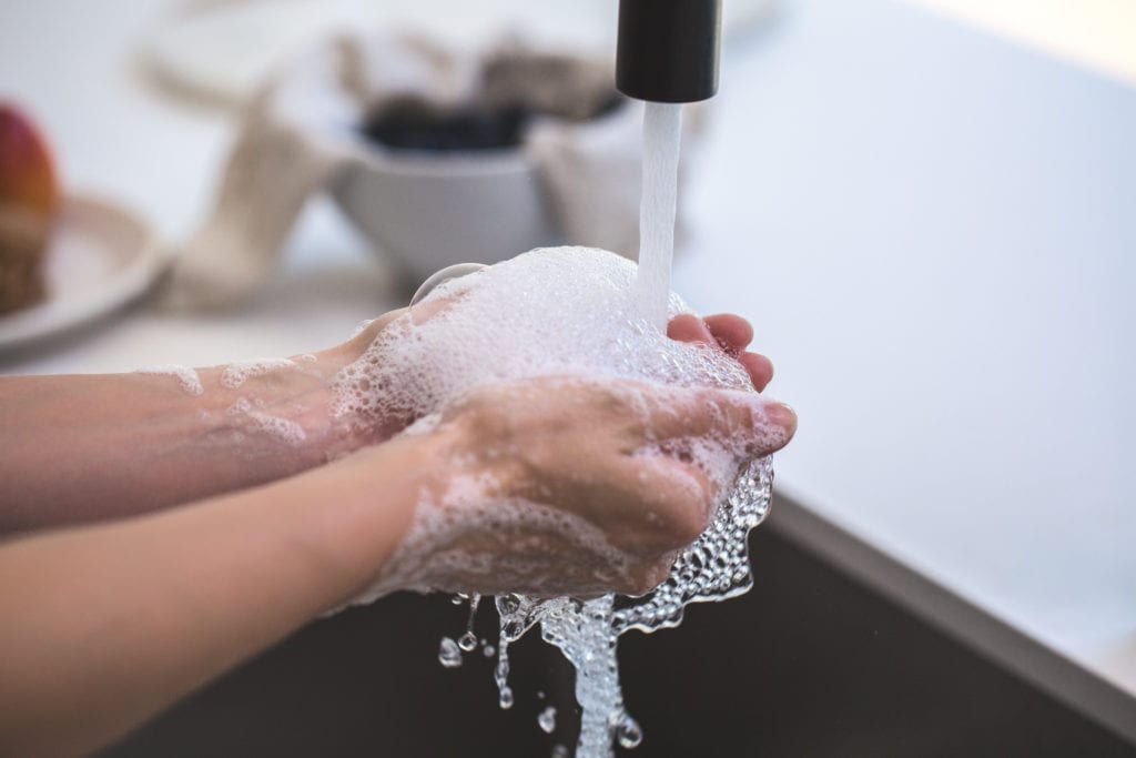 Person washing their hands with soap and water